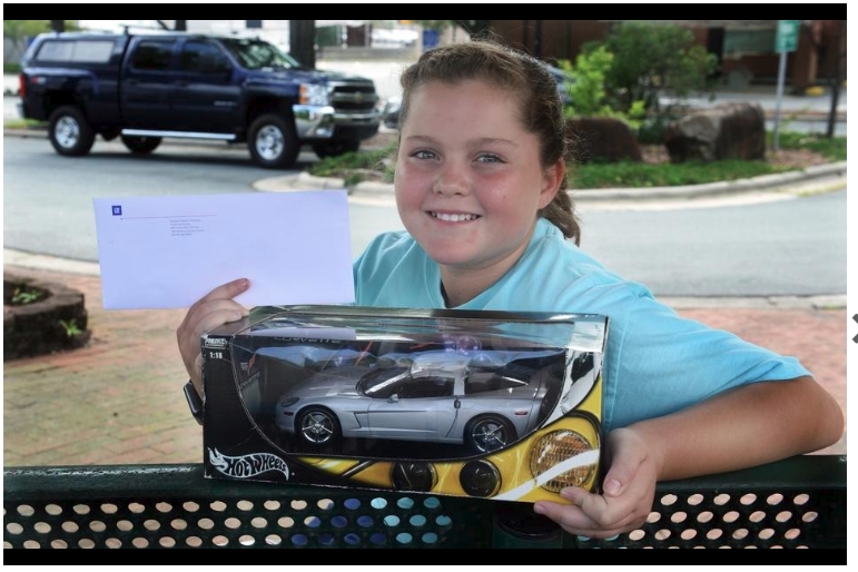 Brianna White, 10, a 4th grade student at E.M. Holt Elementary displays her letter and gift from the CEO of Chevrolet with her father, Chris White and his 2009 Chevrolet Silverado 2500HD pickup truck.